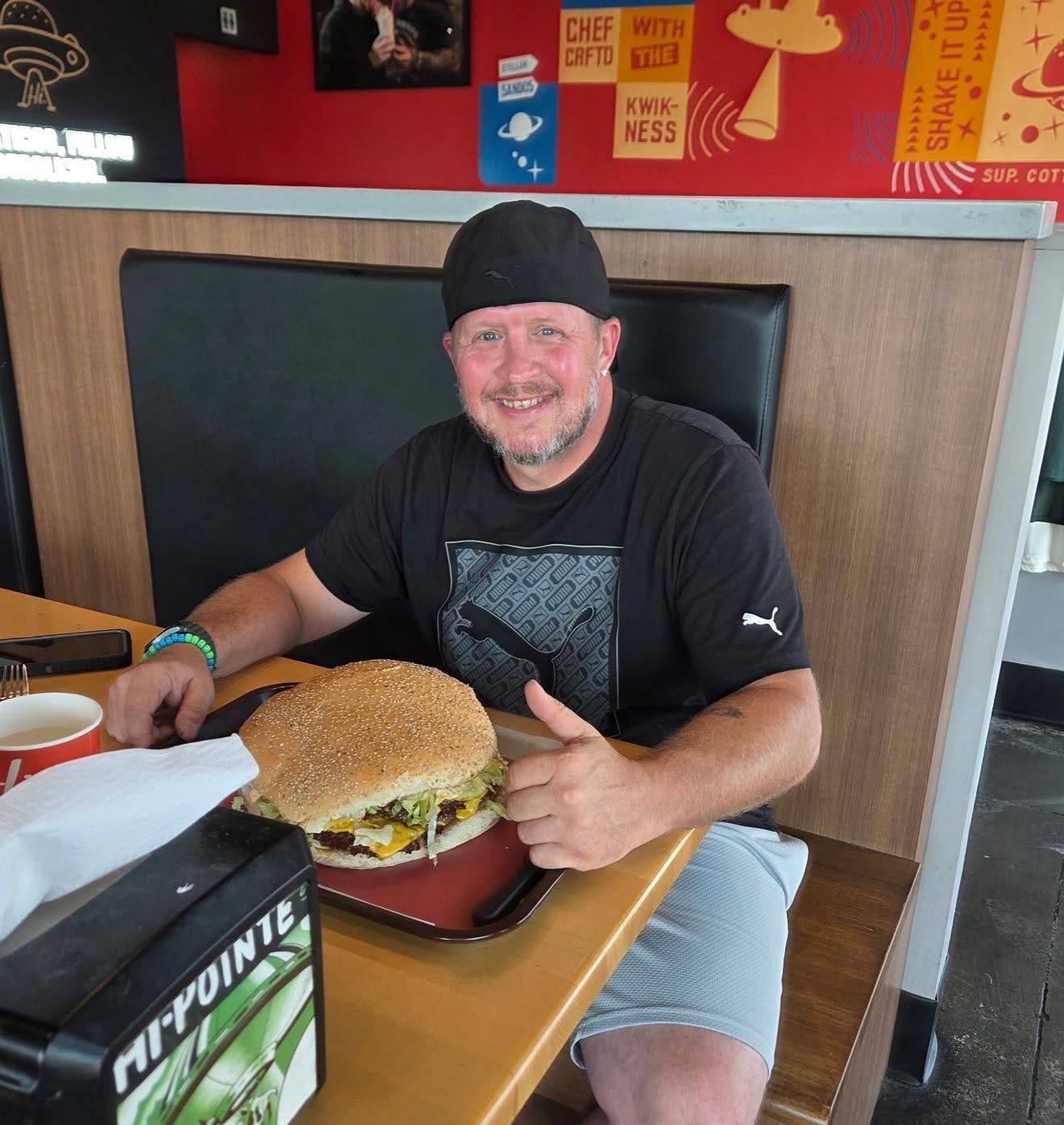 Matt giving a thumbs up behind a giant burger